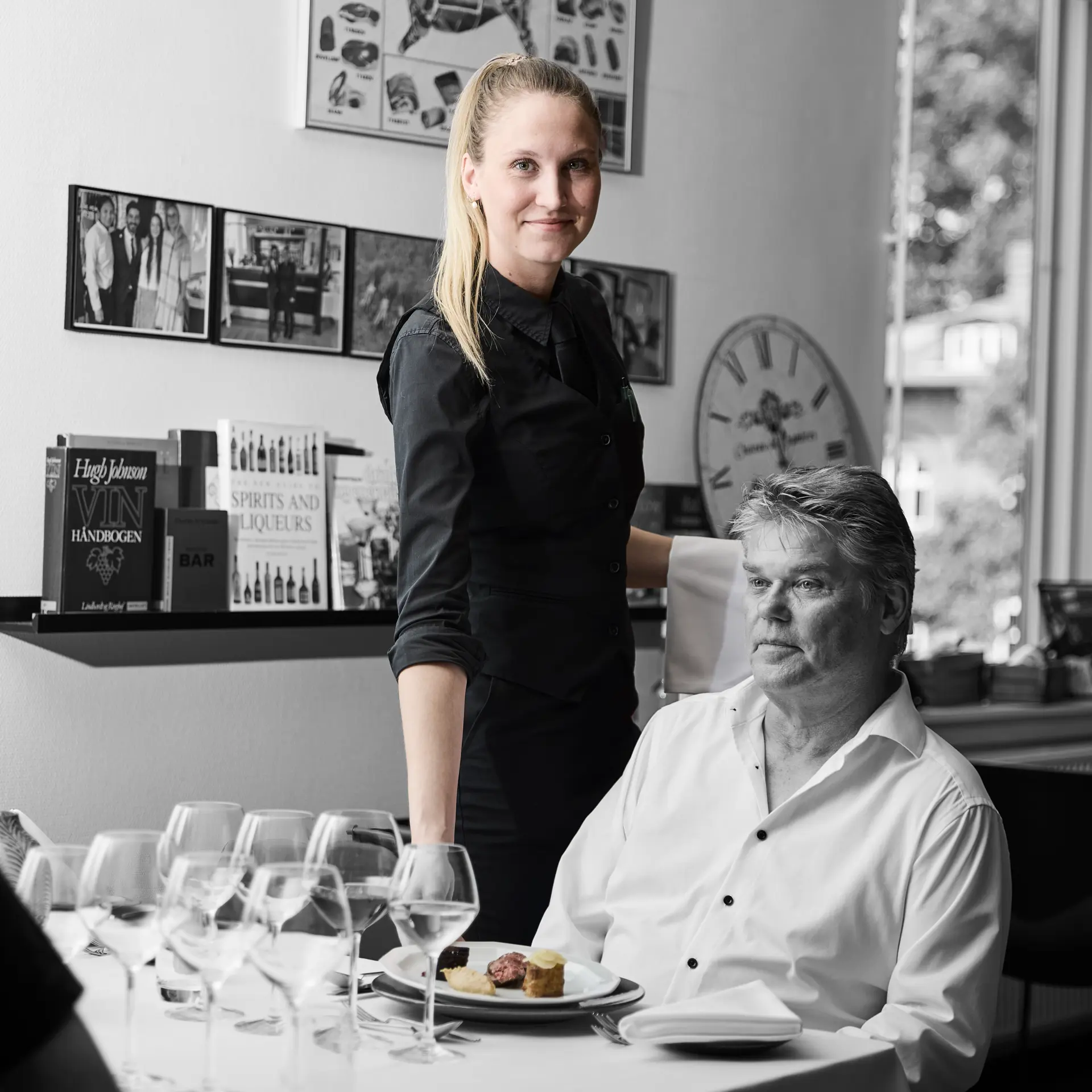 Tjener serverer for et selskab på en restaurant