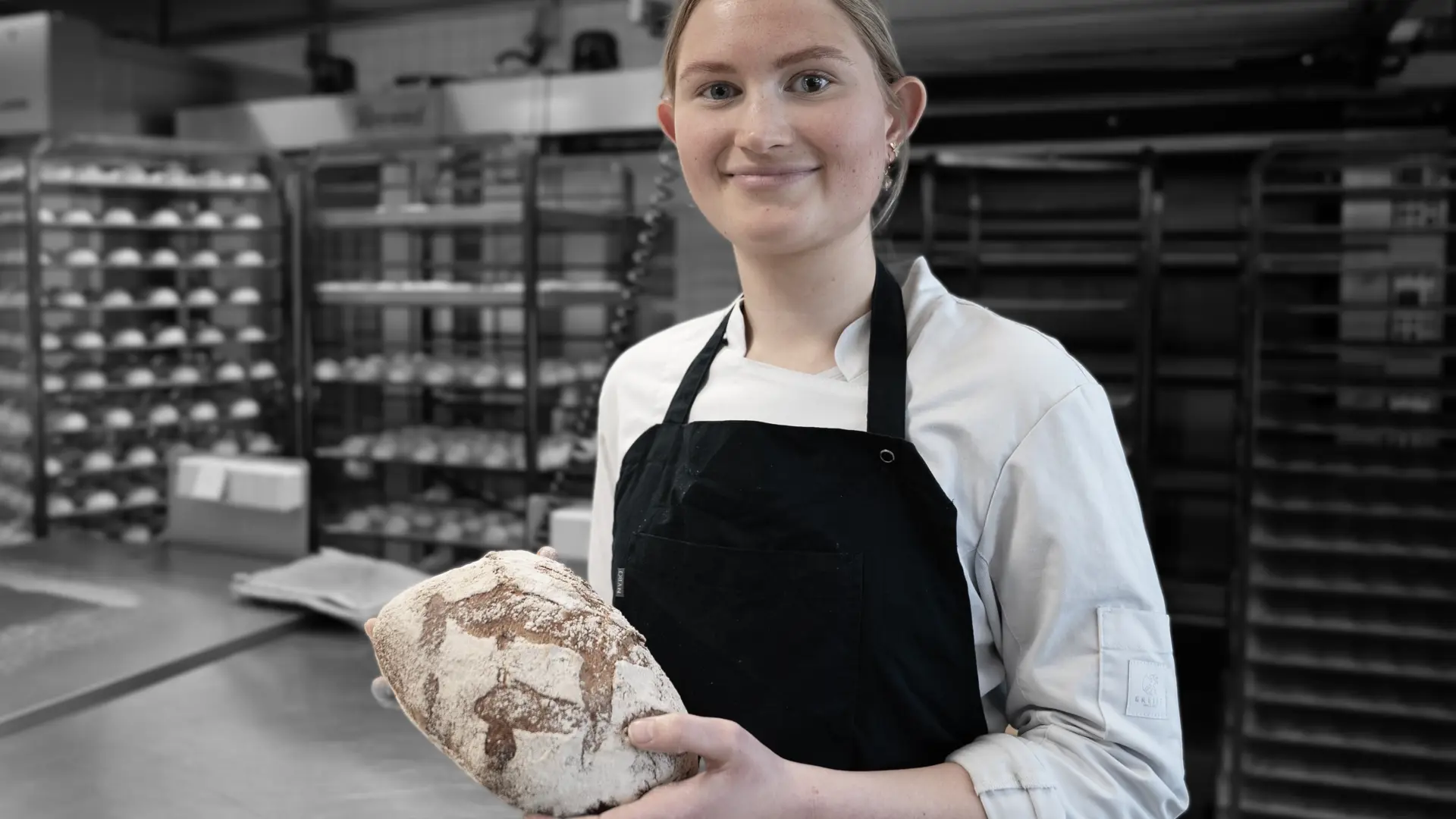 Elev på bager og konditoruddannelsen med friskbagt brød i hænderne